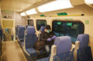 A photo of a man in a face masking riding the GO Train in Toronto.