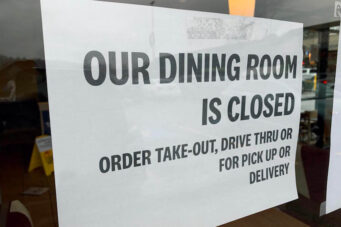 A photo of a takeout and delivery sign in a restaurant window
