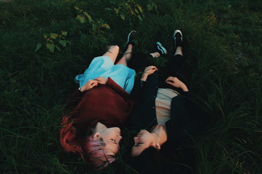 A photo of two people lying close together in a field