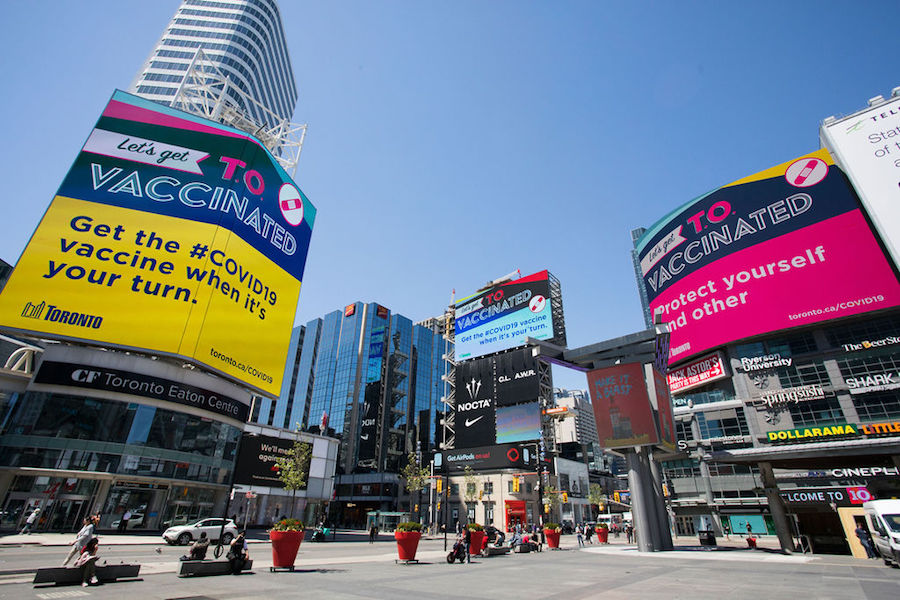 Signs in Yonge-Dundas Square encourage people to get vaccinated in Toronto