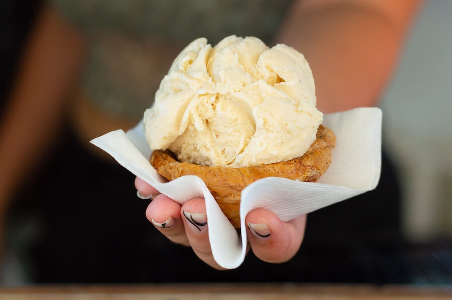 A scoop of pastel de nata (with optional tart-shell bowl) from Mercado Negro's horse trailer.