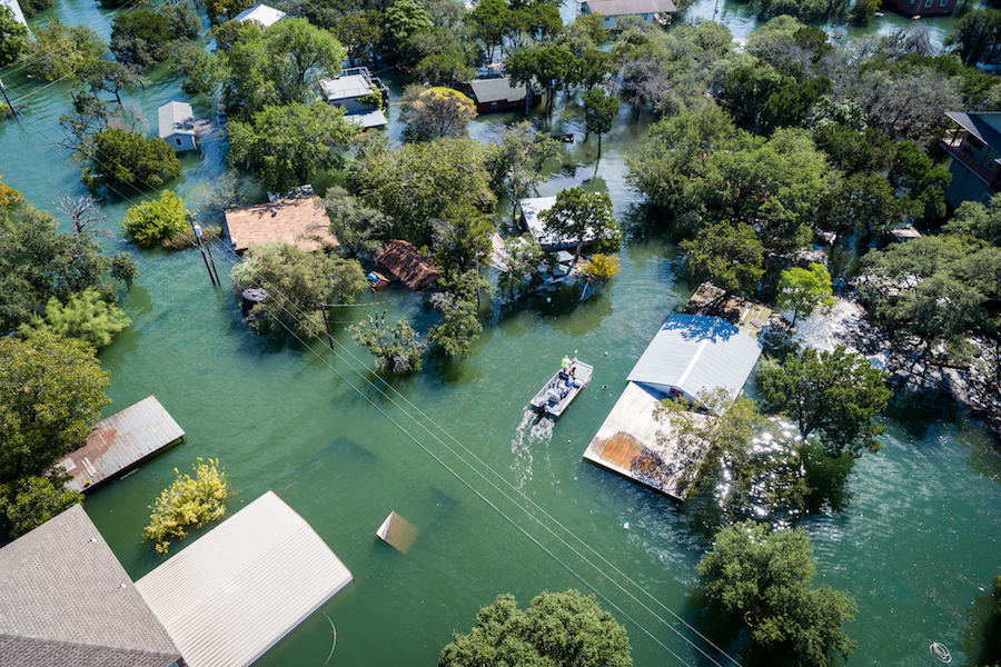 Water Rescue crew on site searching for survivors after dangerous Flooding Aerial drone views high above Flooding caused by Climate Change leaving entire neighborhood
