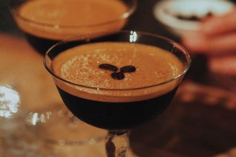 An espresso martini with three coffee beans in the middle