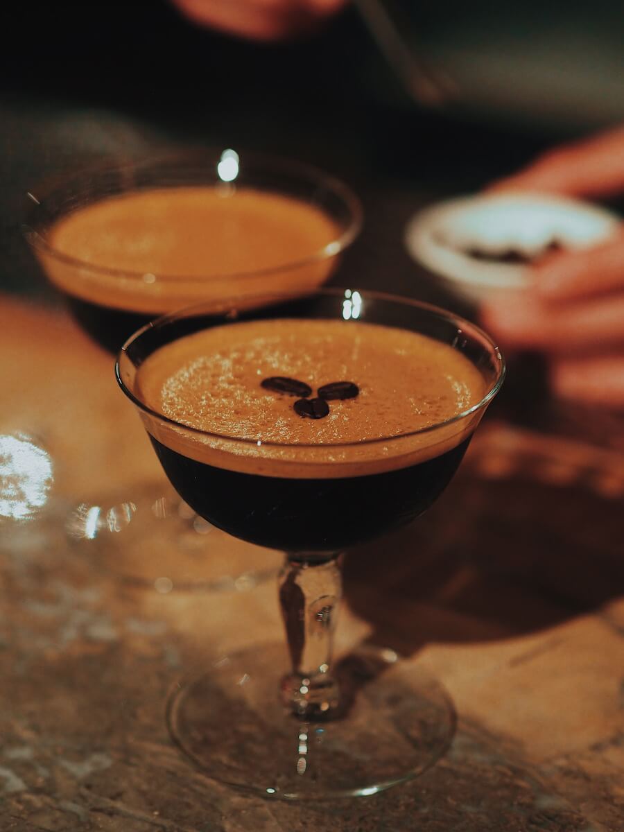 An espresso martini with three coffee beans in the middle
