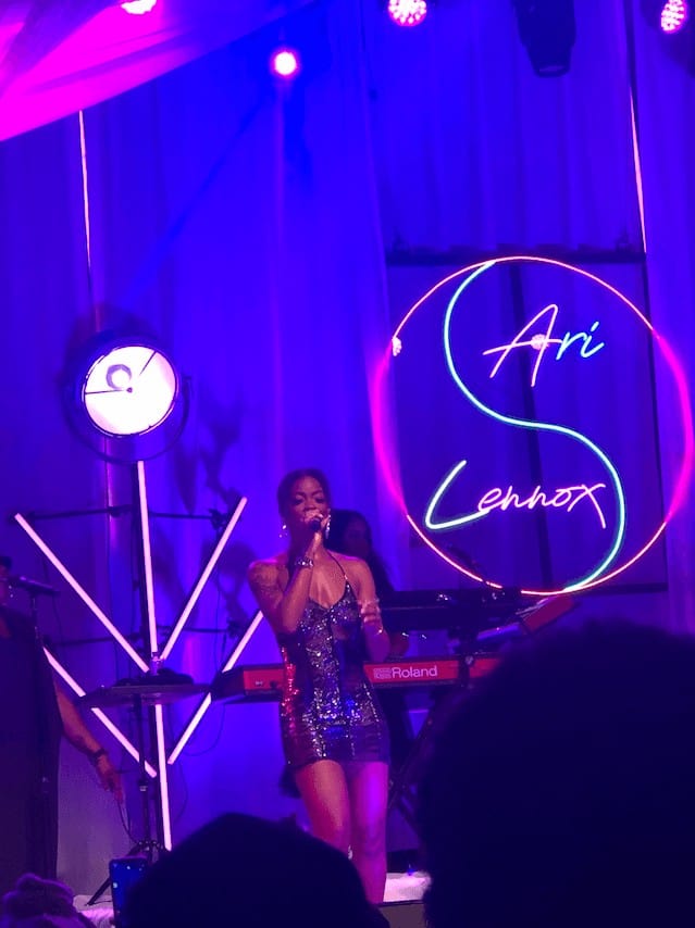 Vibrant live music performance featuring artist Ari Lennox at a Toronto event, with neon lighting and dynamic stage setup, showcasing Toronto's lively entertainment scene.
