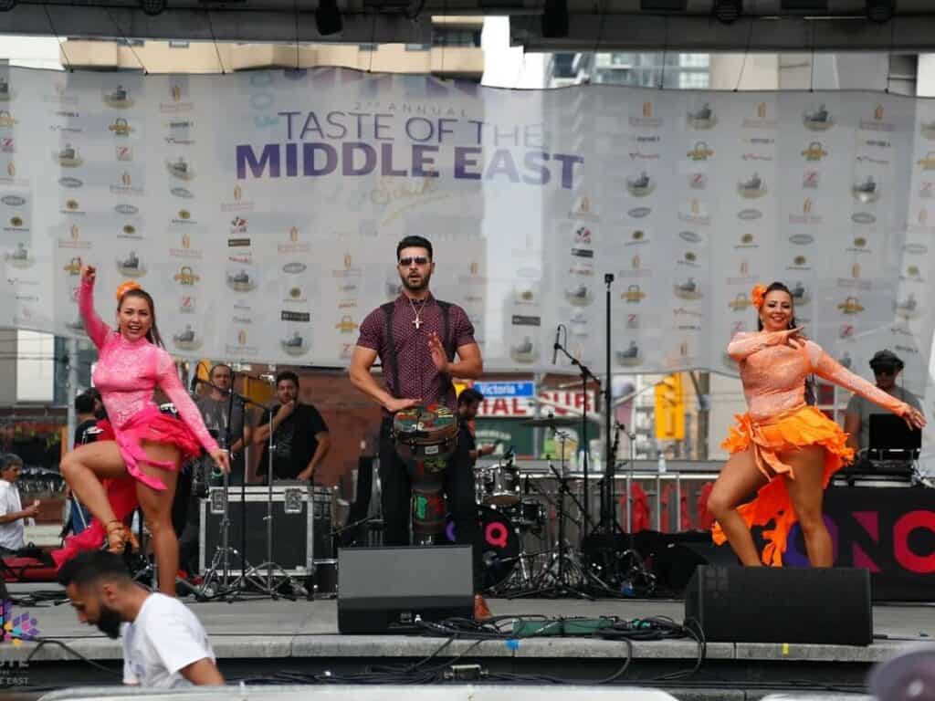Vibrant Middle Eastern cultural dance performance at Toronto’s Taste of the Middle East festival, showcasing live music, traditional costumes, and lively dance routines outdoors in downtown Toronto.
