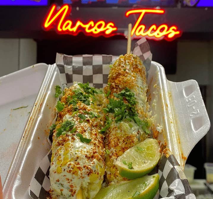 Crispy tacos with fresh cilantro and lime wedges inside a takeaway container at Narcos Tacos, Toronto.