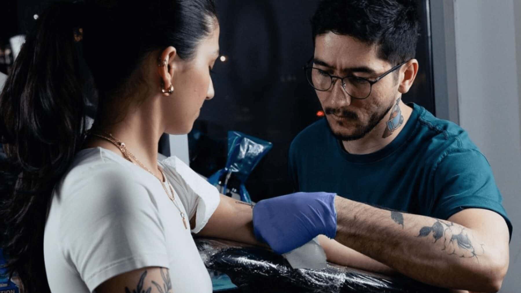 Tattoo artist tattooing woman's arm in a tattoo studio in Toronto, showcasing body art, tattoo design, and ink work expertise.