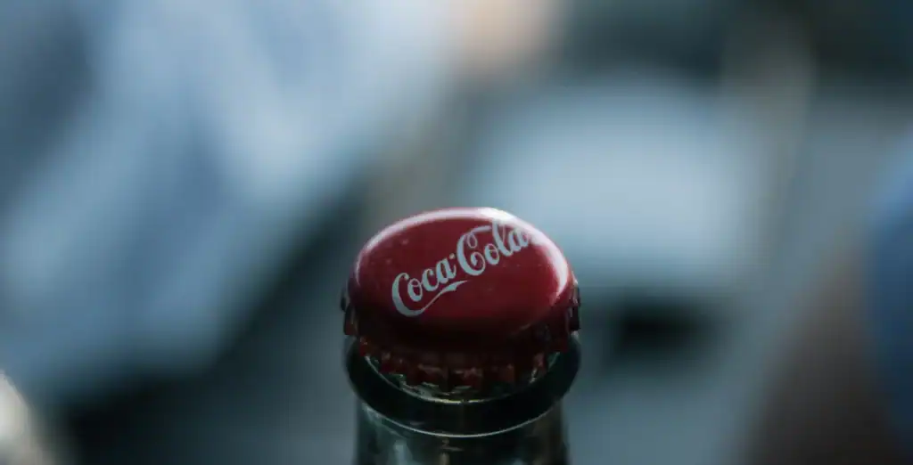 Close-up of a Coca-Cola bottle cap with the iconic logo on it, against a blurred background; showcasing popular beverage branding in Toronto lifestyle imagery.