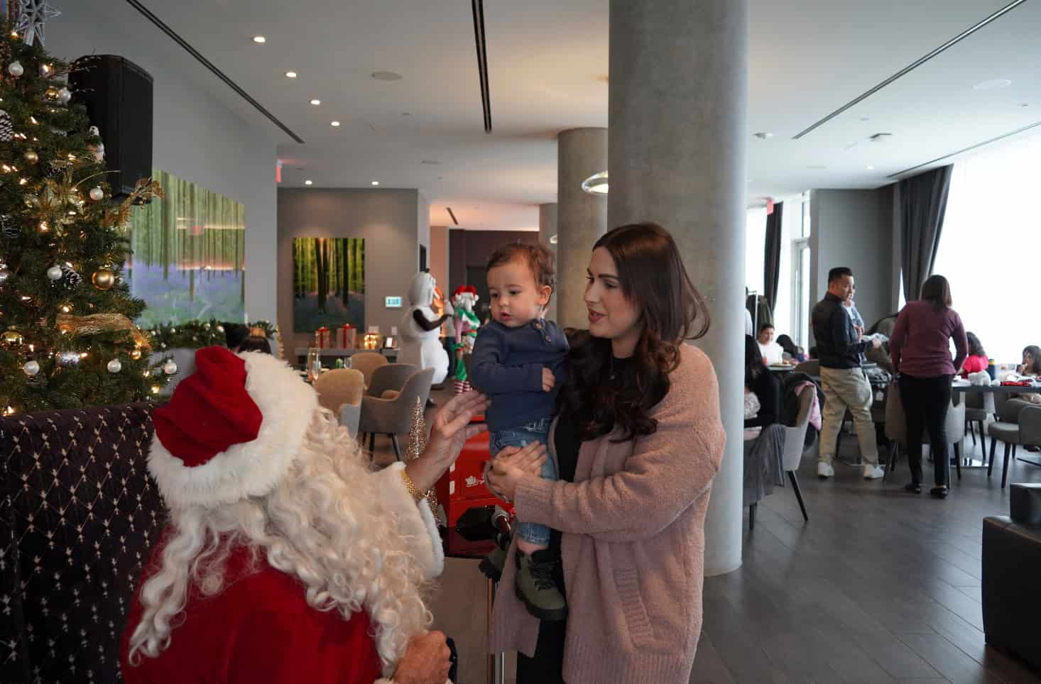 Festive holiday scene with Santa Claus and a young child at a Christmas celebration in downtown Toronto.