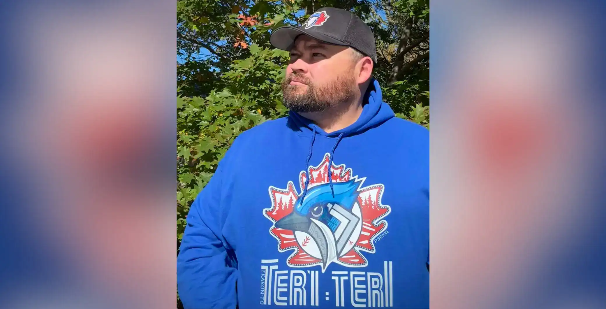 Toronto Maple Leafs hoodie featuring a bird logo and Toronto-themed design, outdoors on a sunny autumn day.