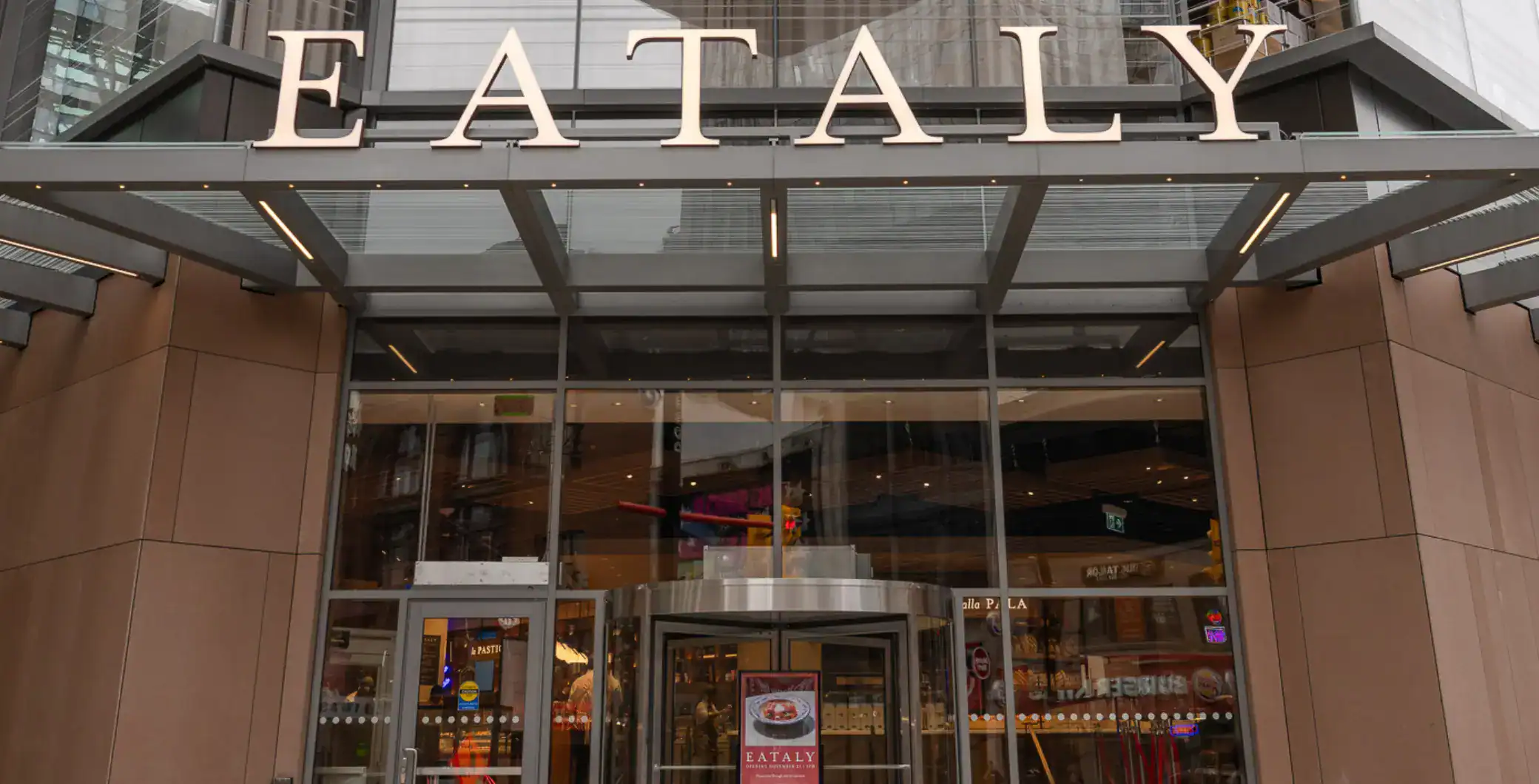 Vibrant downtown Toronto storefront featuring Eataly, an Italian marketplace, with modern architecture, large glass windows, and welcoming entrance for food lovers.