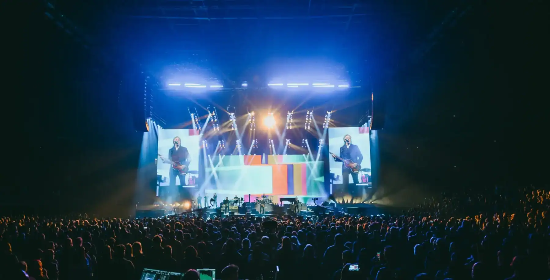 Vibrant concert scene at a Toronto indoor music event with large screens, stage lighting, and a packed audience enjoying live entertainment.