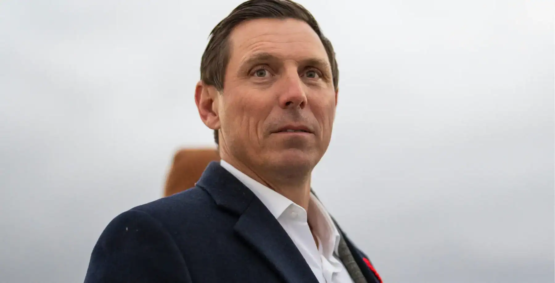 Professional businessman in formal suit, outdoors, overcast sky, Toronto, Ontario, Canada, urban cityscape background.