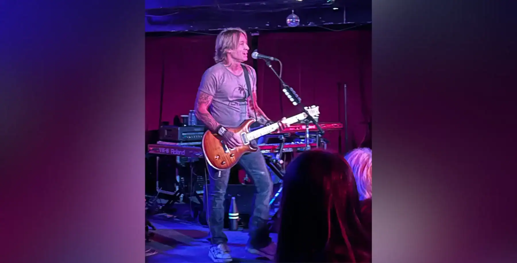 Energetic musician performing live on stage with guitar at a concert in Toronto, vibrant music scene, night life, local entertainment, Toronto music events.