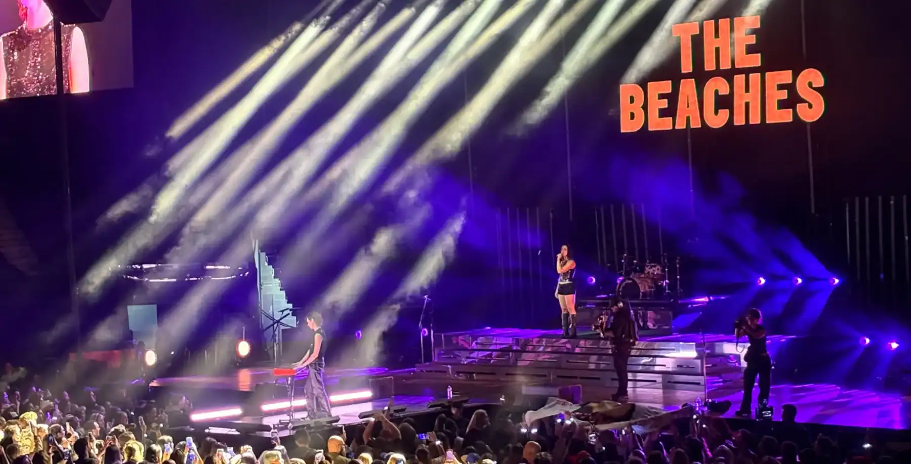 Vibrant concert scene at The Beaches in Toronto featuring a live performance with colorful stage lights and an enthusiastic crowd enjoying the show.