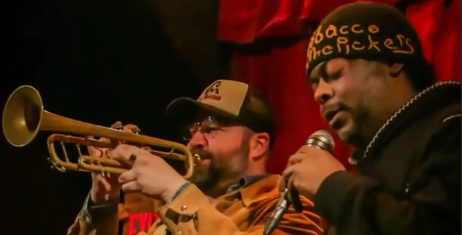 Vibrant live performance featuring jazz musicians with trumpet and microphone at a cozy Toronto venue.