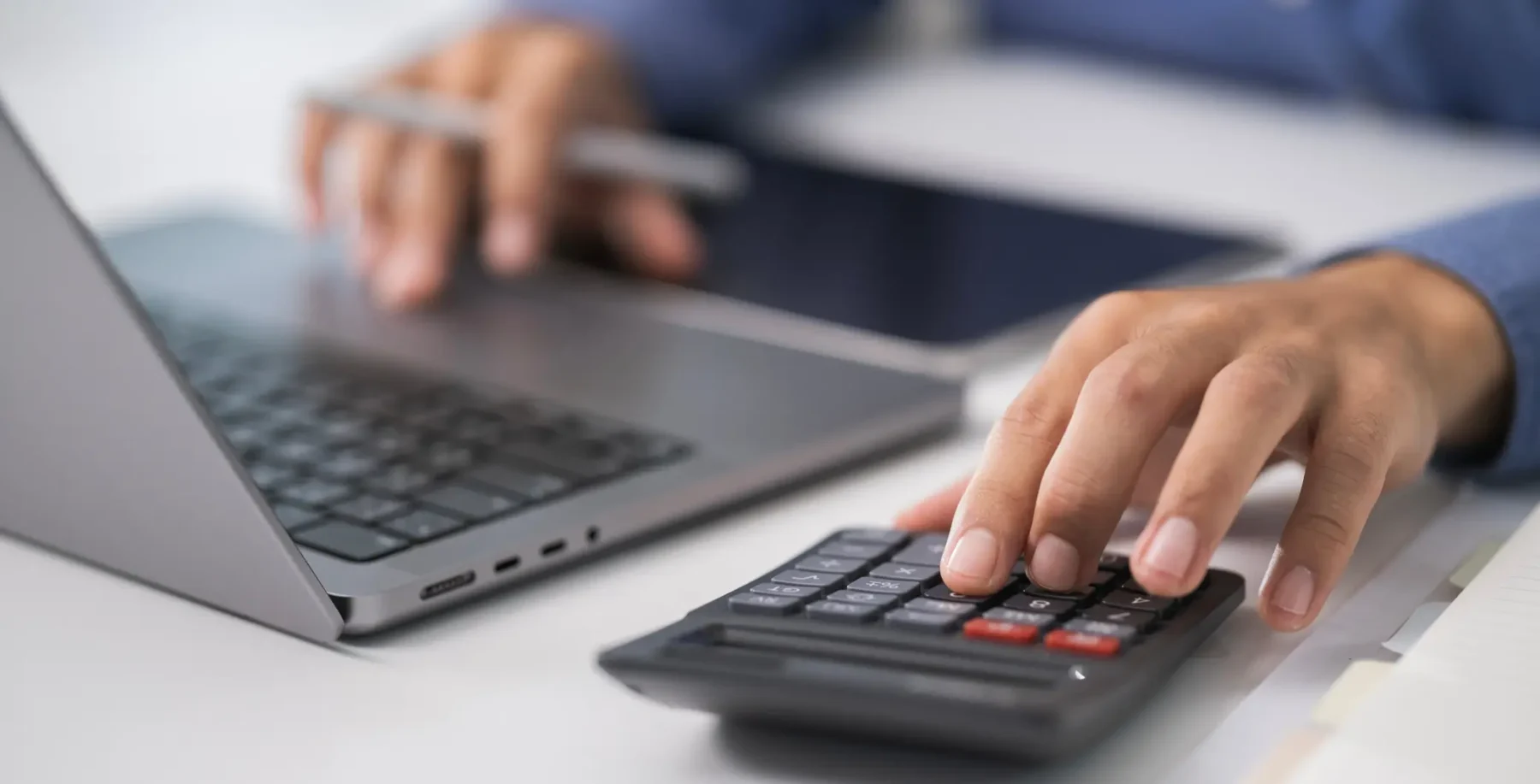 Close-up of a person using a calculator and laptop to declare their Vacant Home Tax in Toronto, emphasizing the deadline for homeowners to avoid penalties.