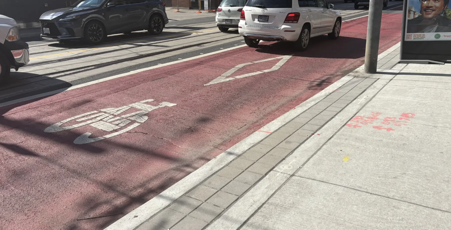 Red transit lane on Bathurst Street in Toronto, temporarily closed for construction work, set to reopen before FIFA World Cup, improving transit flow and safety.