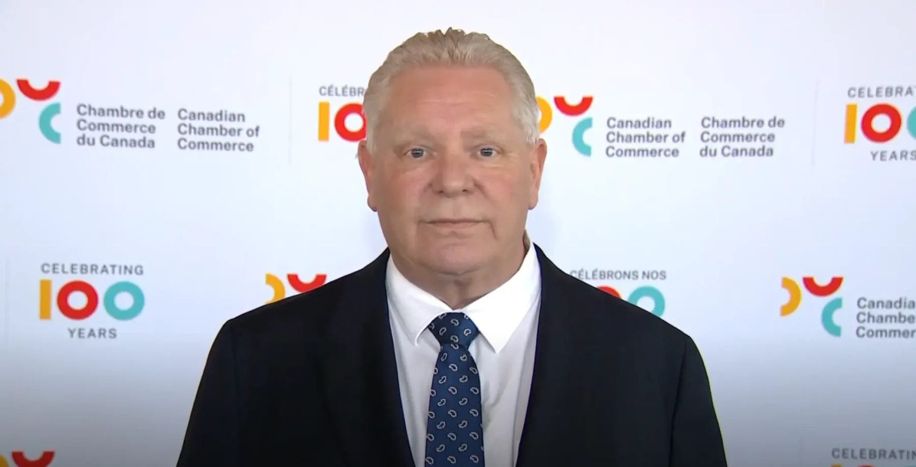 Ontario Premier Doug Ford speaking at Canadian Chamber of Commerce event, highlighting recent controversy over selling a purchased jet amid public backlash.