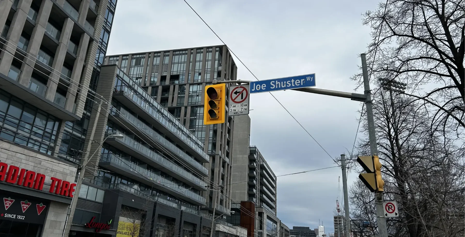 Toronto Hydro crews working on power outage in Liberty Village, Toronto, with traffic lights and street signs visible during cloudy weather.