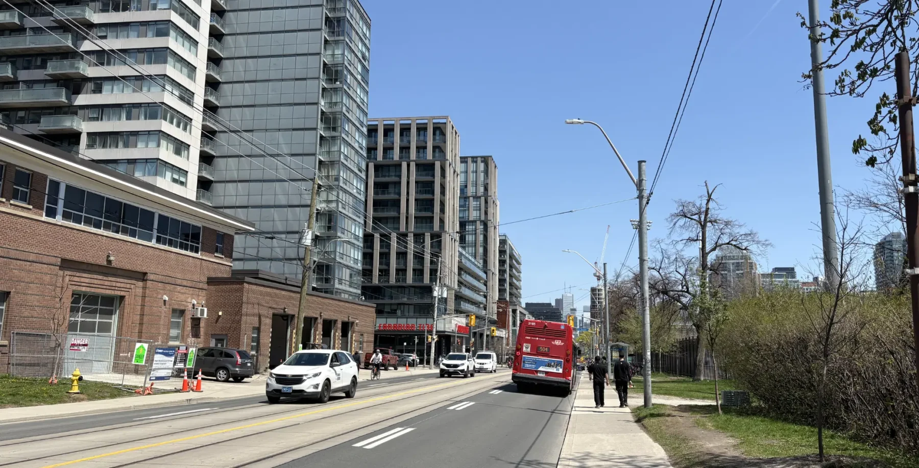 A view of Toronto's downtown with modern high-rise buildings, busy street, and pedestrians on a clear day, illustrating the city's urban environment and changing weather patterns.