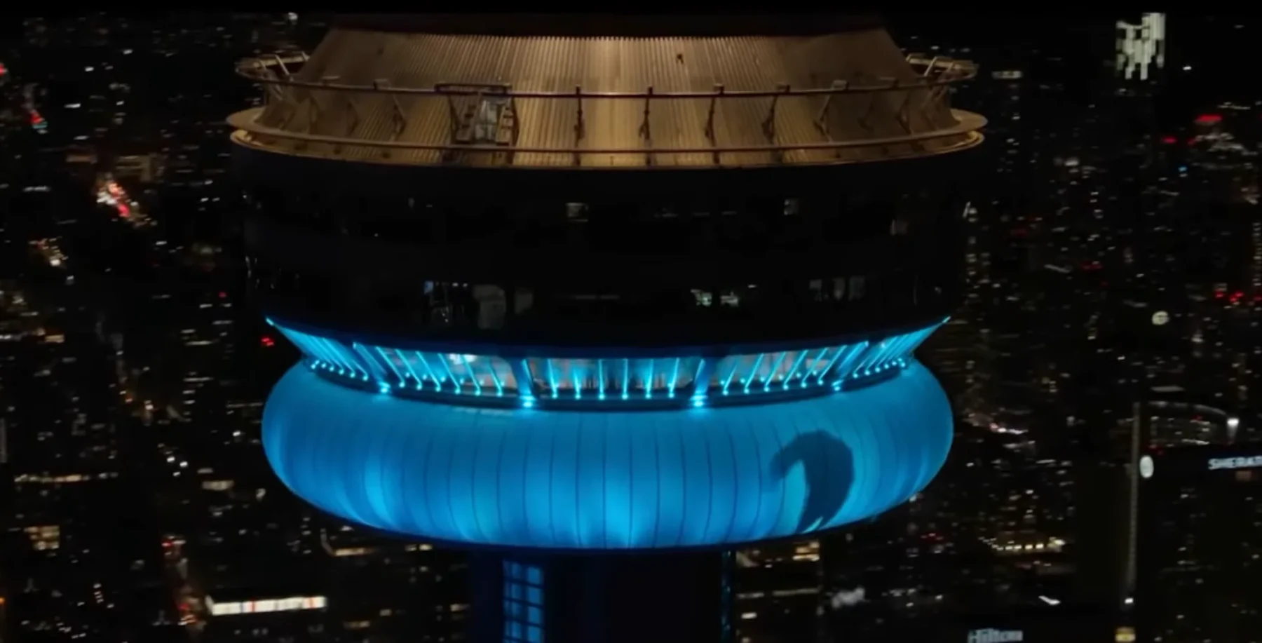 Toronto CN Tower at night with blue lighting, showcasing the iconic skyscraper in the city skyline, a popular landmark and tourist attraction in Toronto.