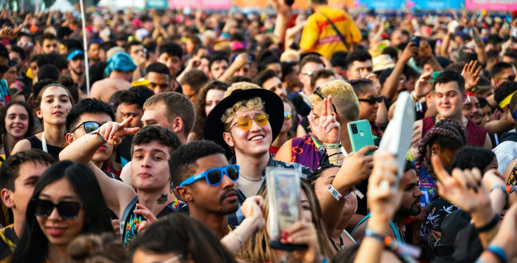 Crowd of diverse festivalgoers enjoying music and dancing at a lively outdoor event in Toronto.