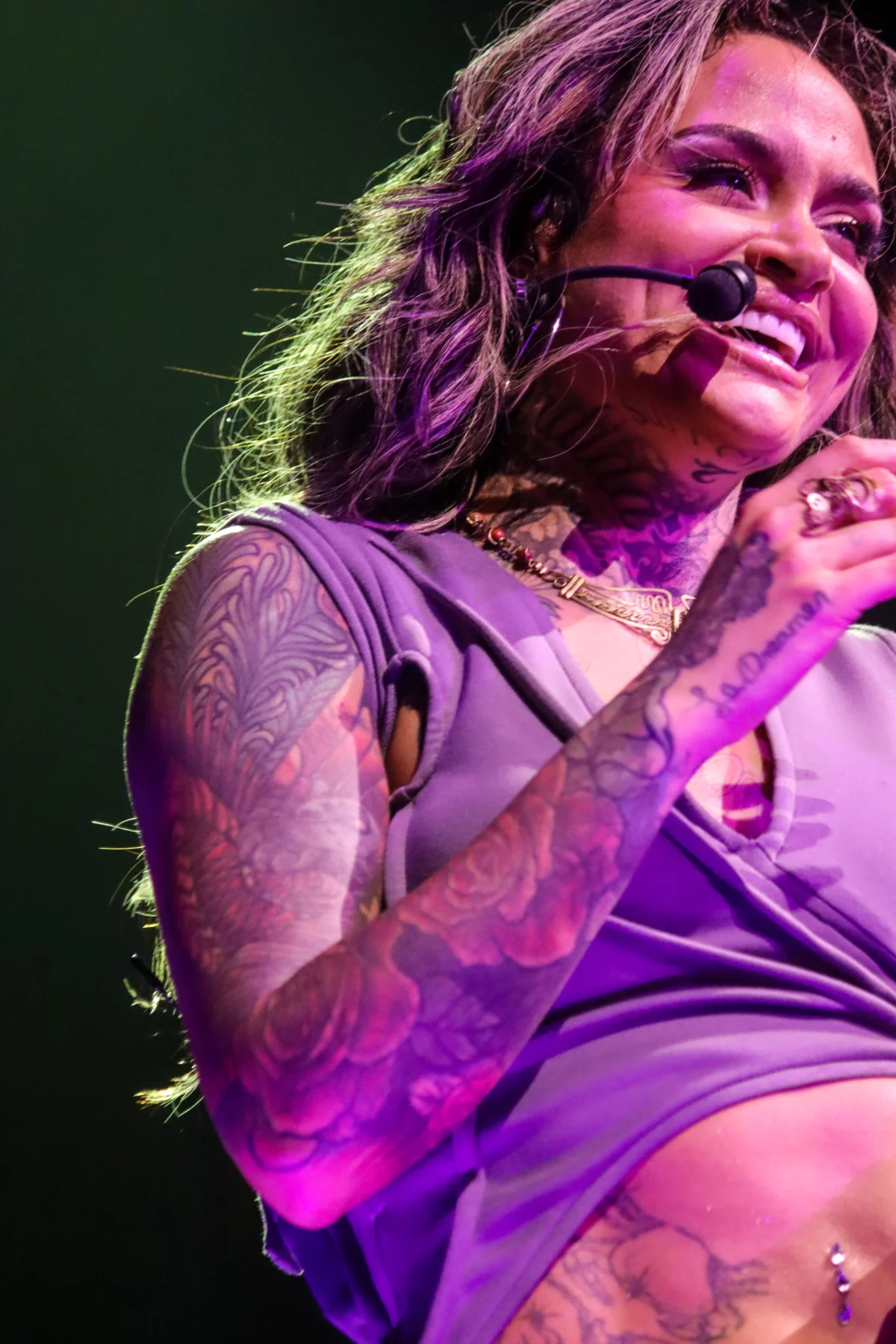 Kehlani performing on stage in Toronto, showcasing her tattoos and vibrant stage presence during a lively concert.