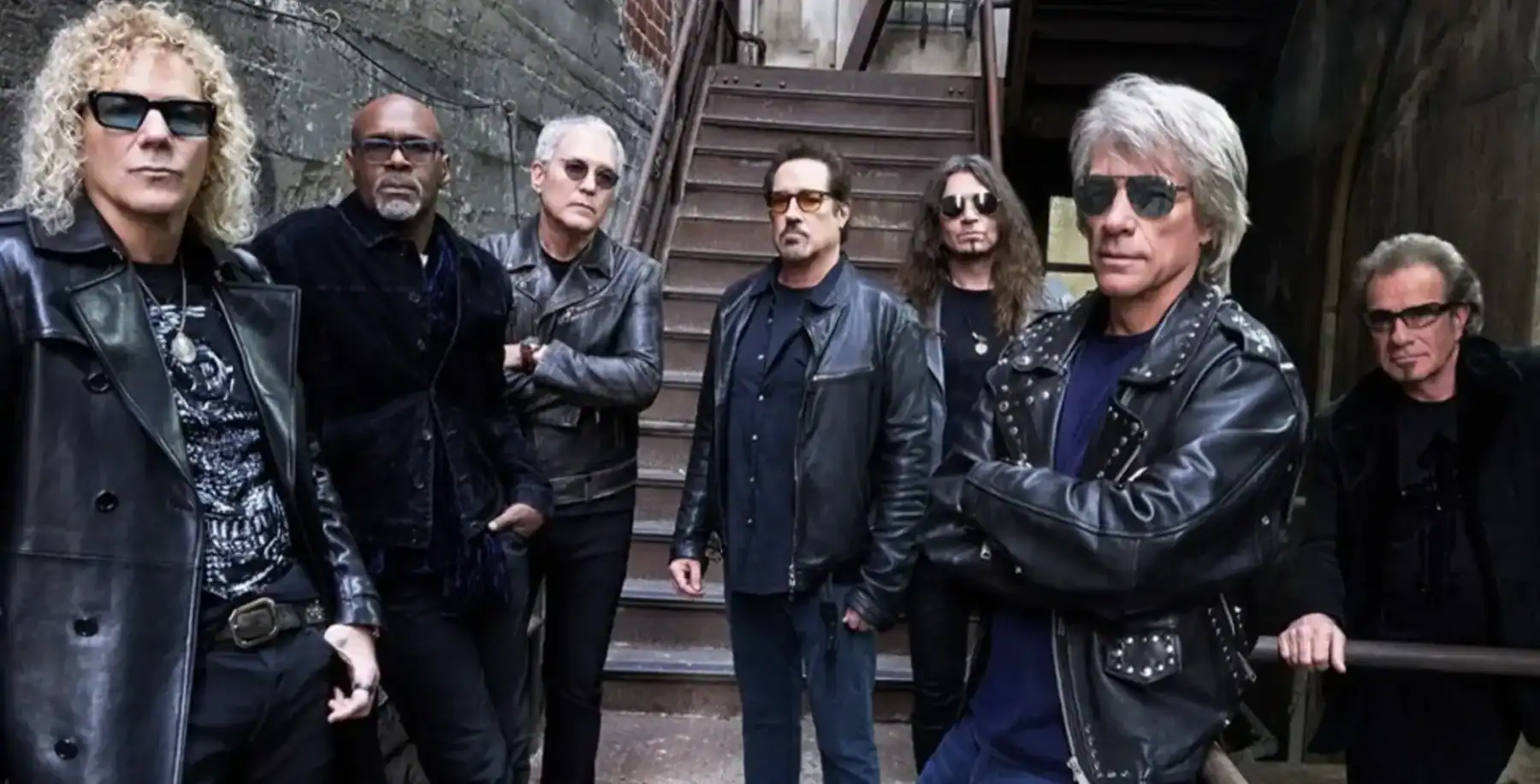 Bon Jovi band members pose outdoors near a staircase, dressed in dark leather jackets and sunglasses, promoting their Toronto 2027 concert at Rogers Stadium.