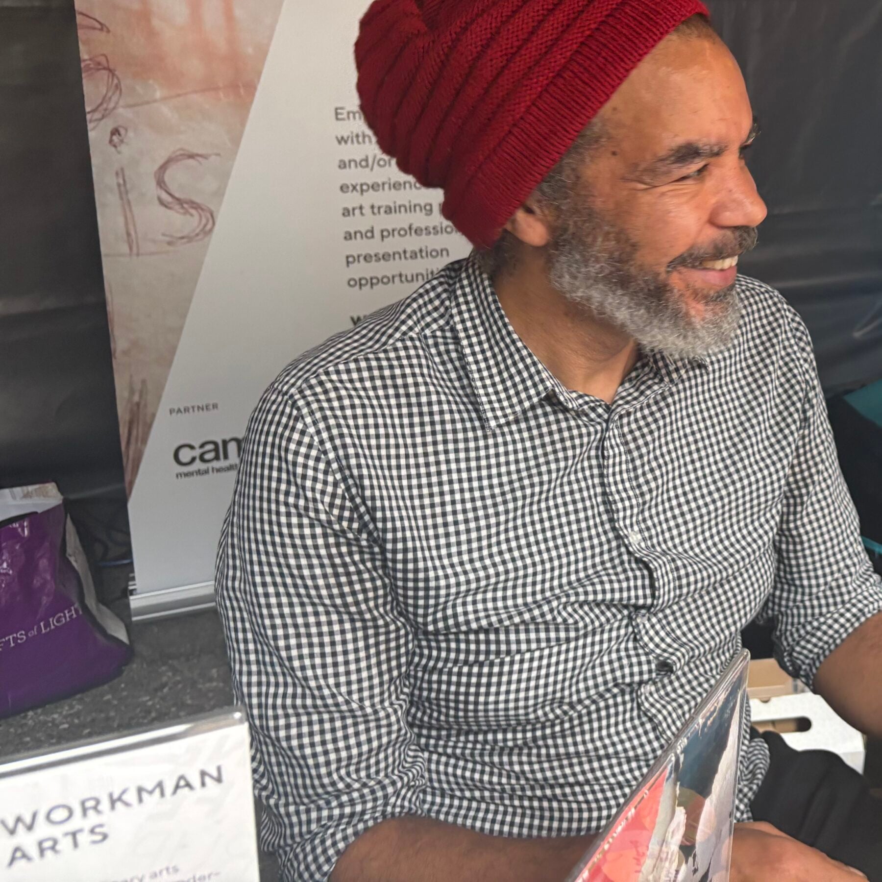 A smiling man with a red beanie and checkered shirt at the Rendezvous with Madness festival in Toronto.