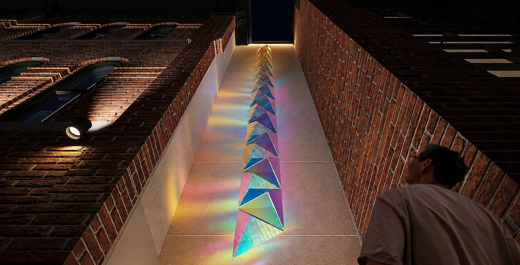Colorful illuminated geometric art installation on a narrow outdoor corridor between brick buildings in Toronto.