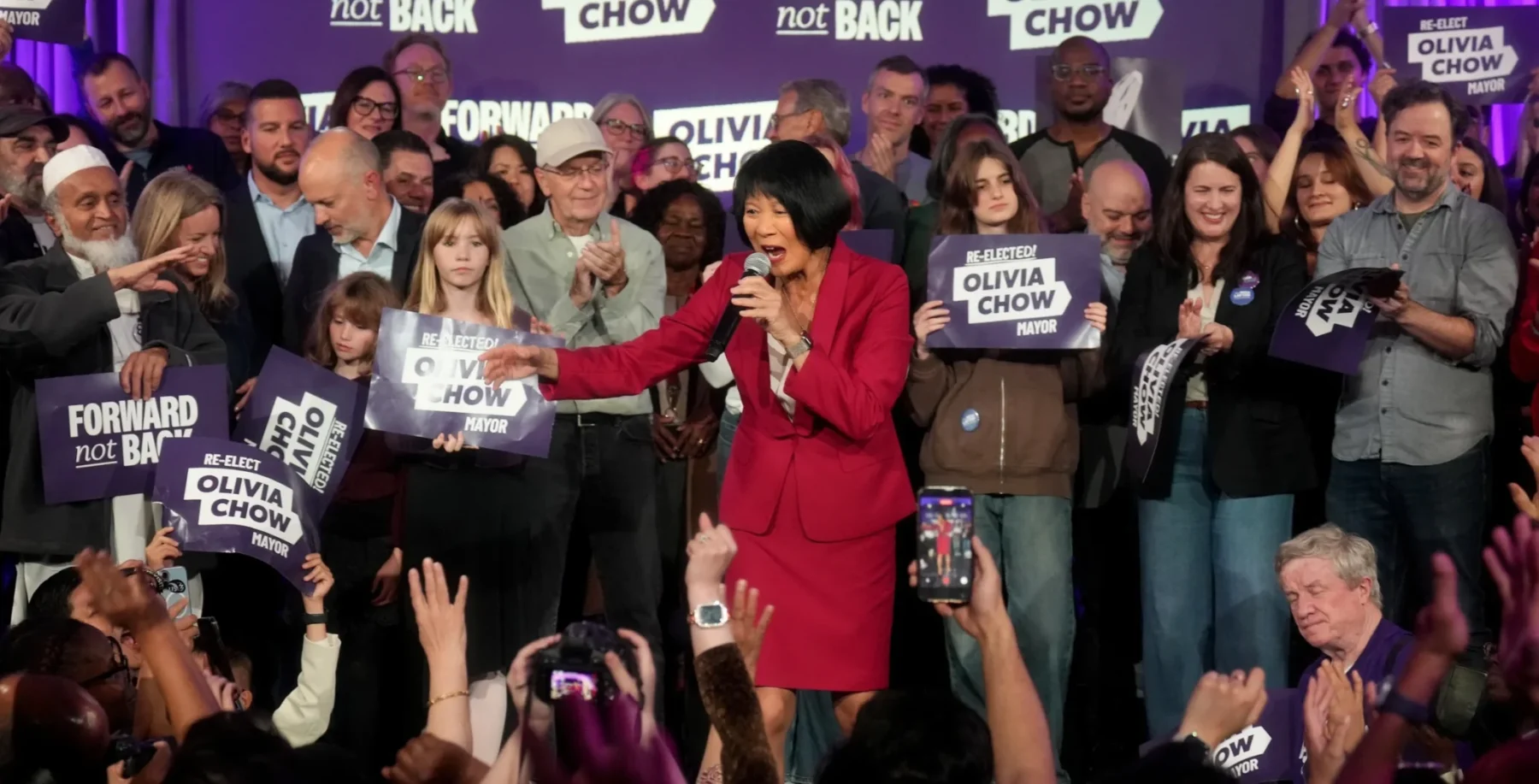 NOW Toronto event featuring Olivia Chow speaking on stage with supporters holding signs and cheering at a political rally.