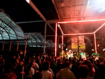 Vibrant live music performance at an outdoor Toronto event with a lively crowd, illuminated stage, and modern stage design featuring neon lights, showcasing Toronto's arts and entertainment scene.
