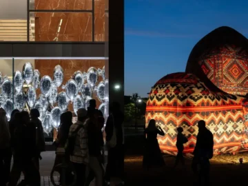 Nighttime view of illuminated art installations at Nuit Blanche Toronto, with visitors exploring outdoor exhibits and vibrant light displays.