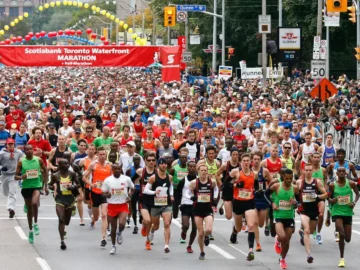Large group of marathon runners crossing the start line at the Toronto Waterfront Marathon in Toronto, Canada.